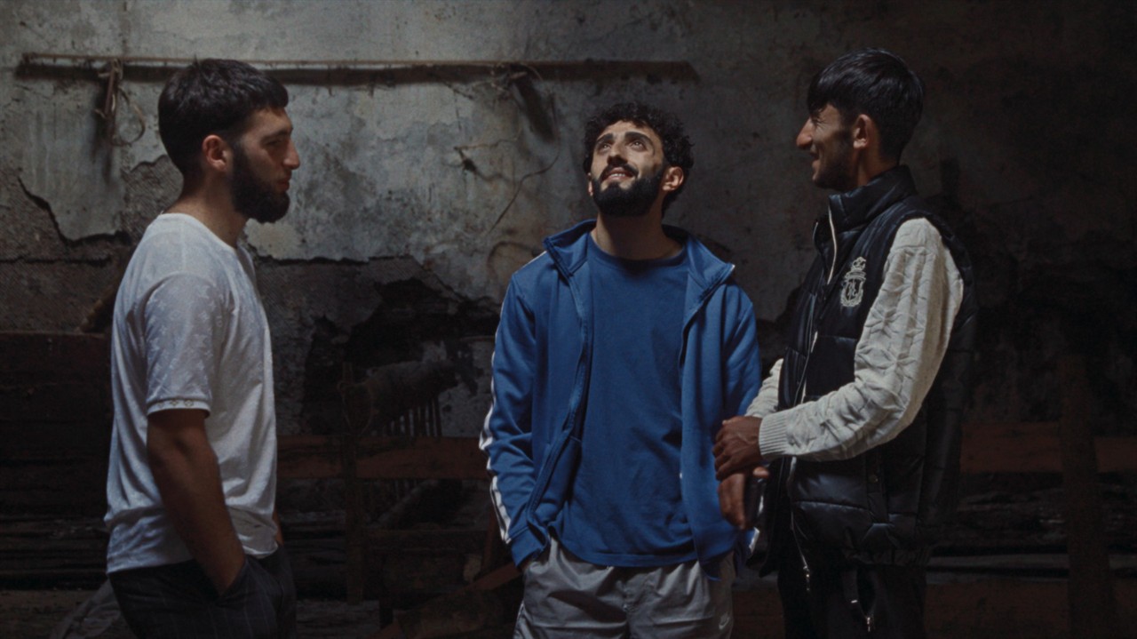 Three men stand in a semi-circle